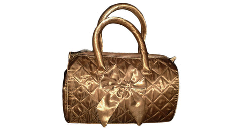 Golden color handbag with bow.   Bolsa de color dorado con un lazo